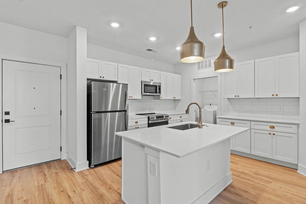 A modern kitchen with white cabinets and a central island.