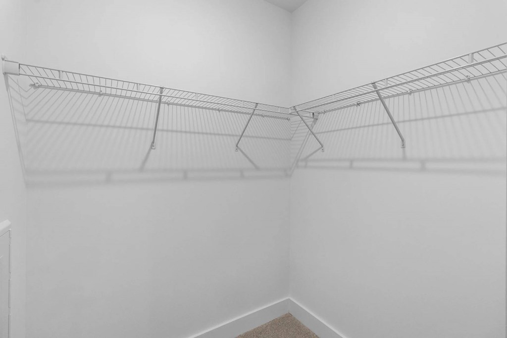 Empty wire shelving in a white room.