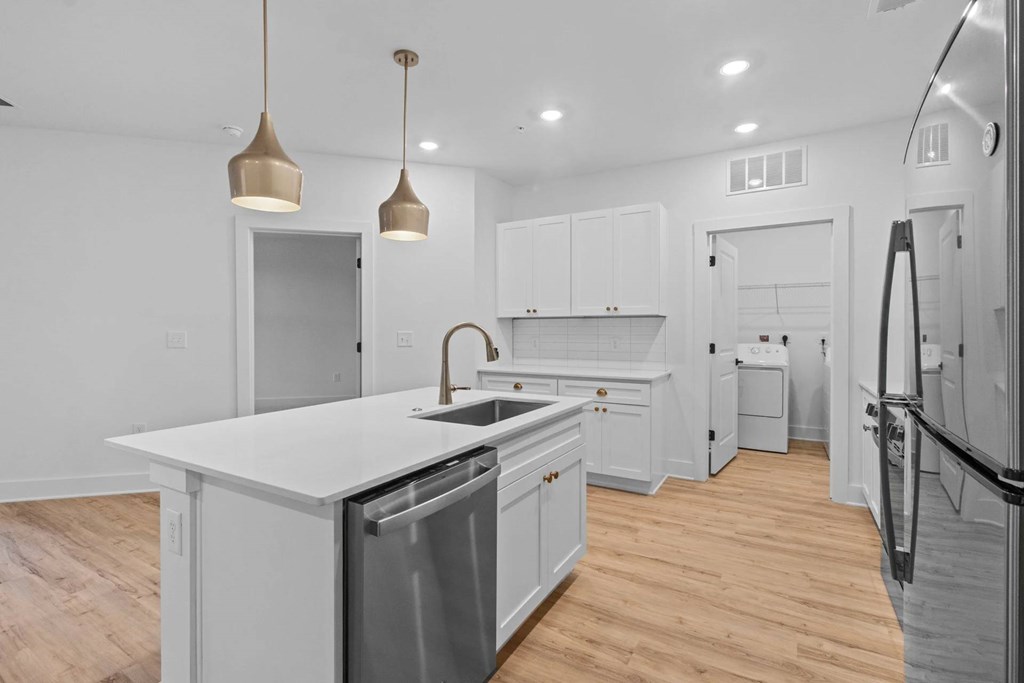 A kitchen with a white counter top and a dishwasher.