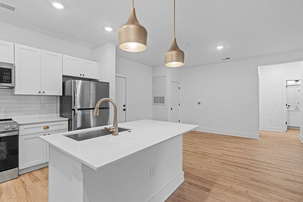 A modern kitchen with a white island and stainless steel appliances.