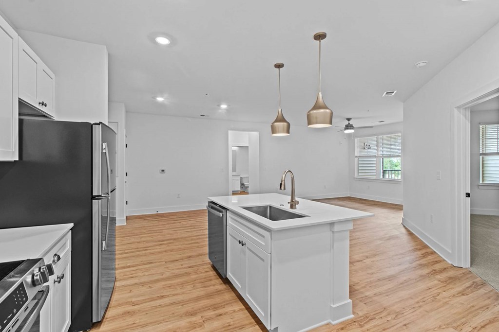 A kitchen with a black refrigerator and white cabinets.