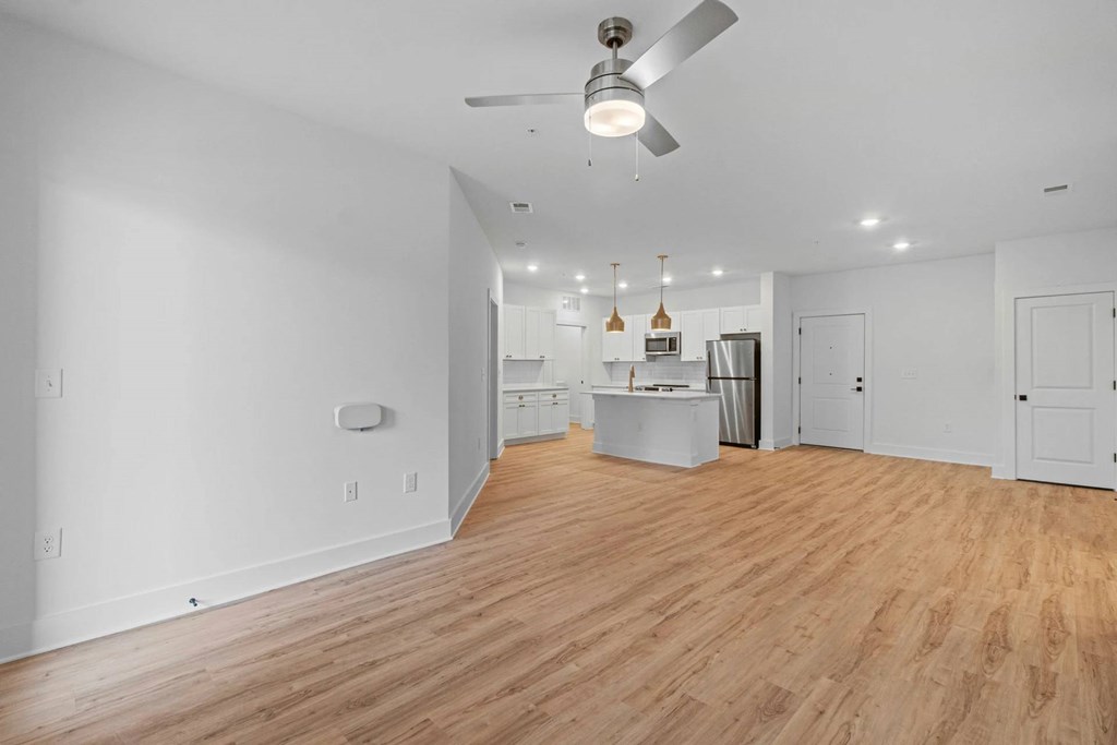 A room with a ceiling fan and wooden flooring.