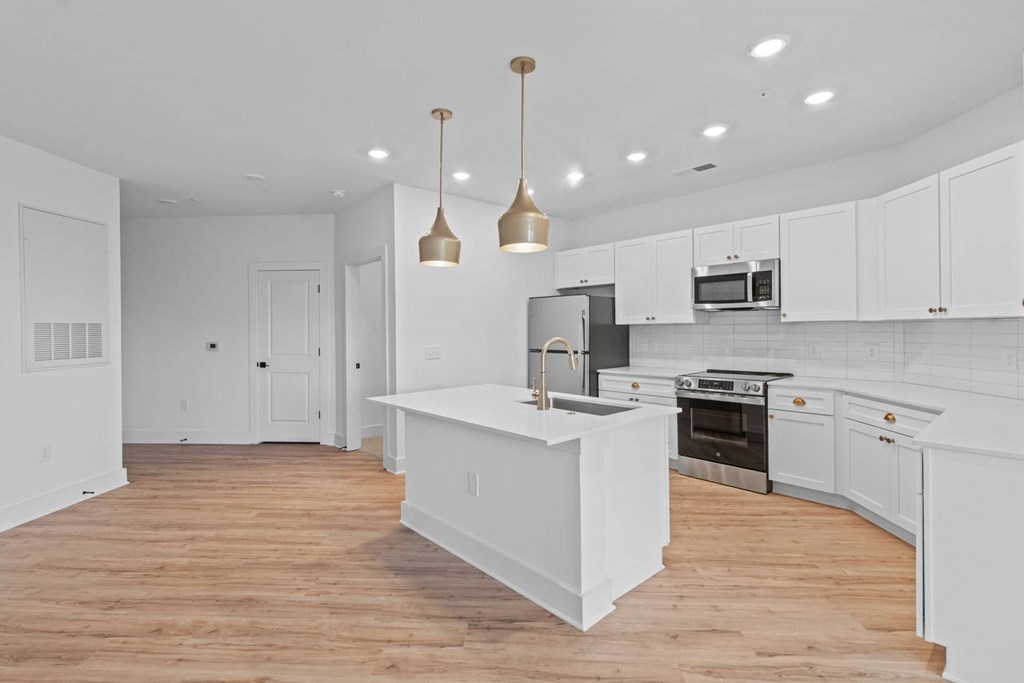 A kitchen with white cabinets and a wooden island.