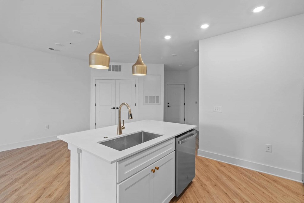 A kitchen with a white countertop and a sink.