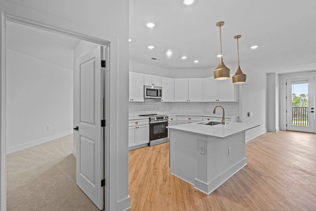 A kitchen with white cabinets and a sink.