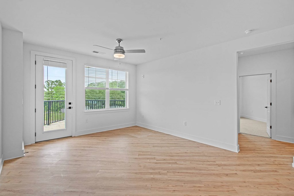 A room with a ceiling fan and a sliding glass door.