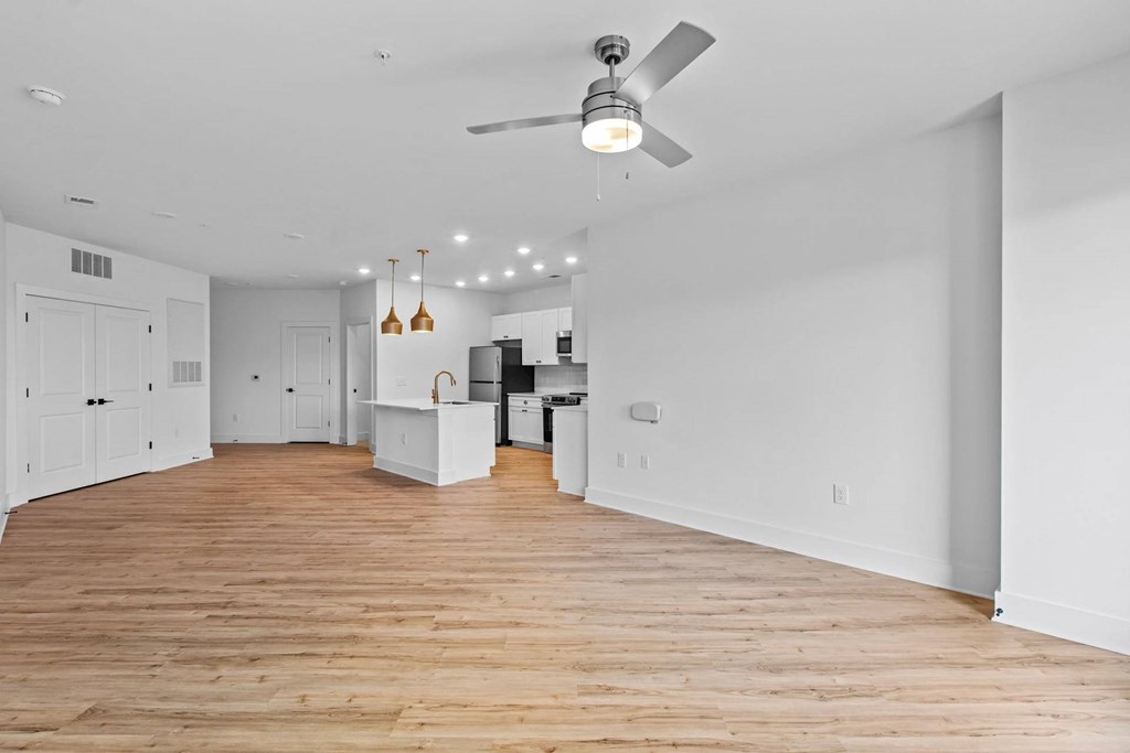 A room with a ceiling fan and wooden flooring.