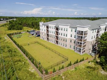 A large white building with a green lawn in front.