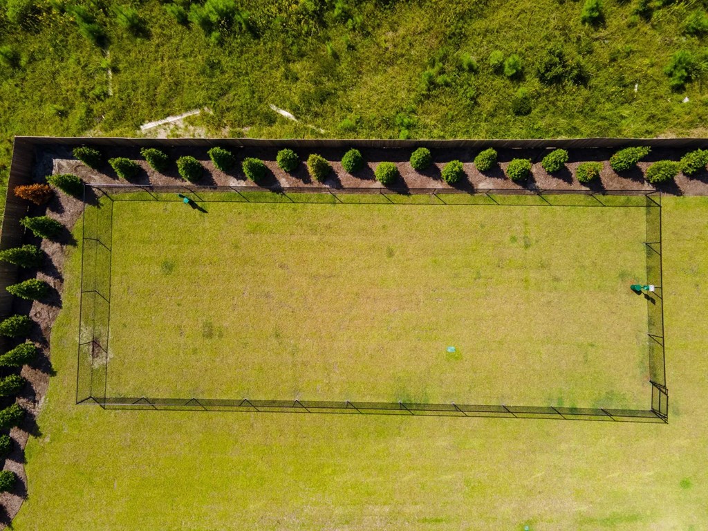 A rectangular green field surrounded by a fence.