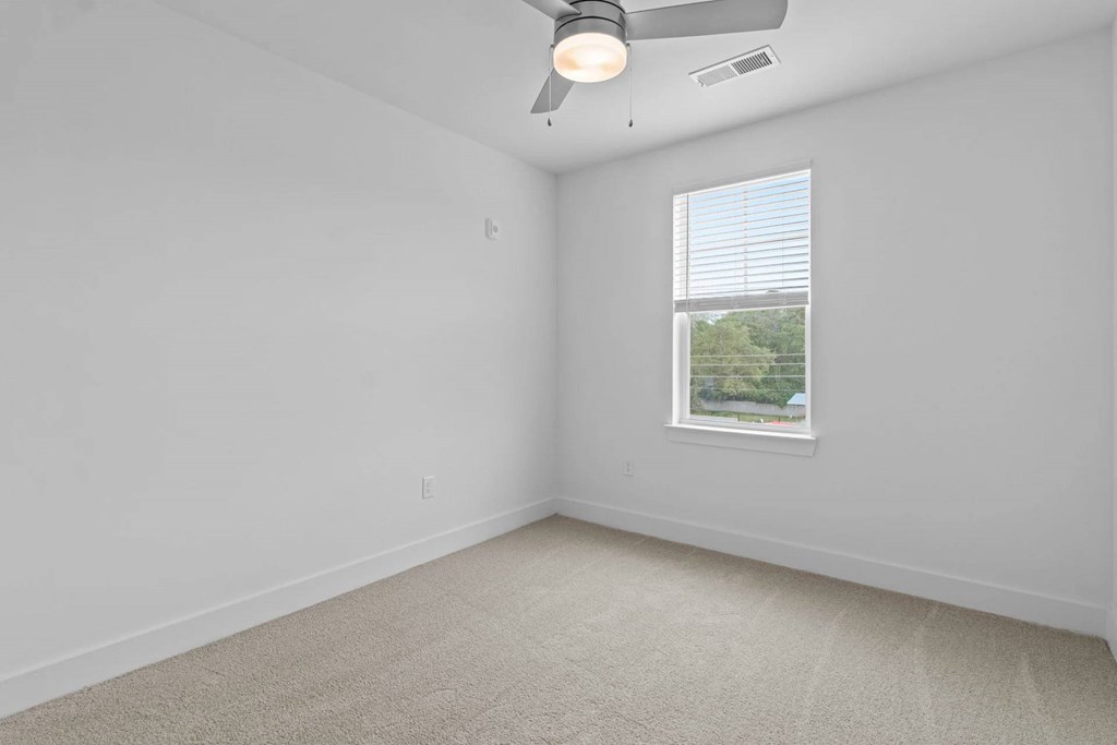 A room with a window and a ceiling fan.