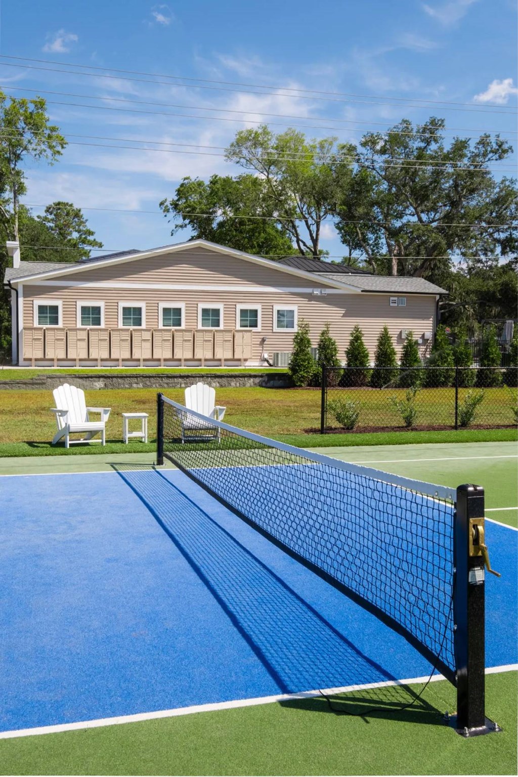 A tennis court with a blue surface and a black net.