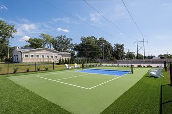 A tennis court with a white building in the background.