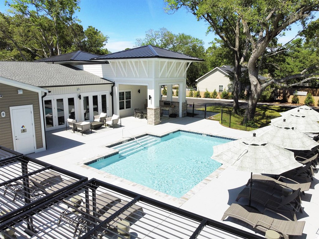 A pool with a black railing and a white umbrella.
