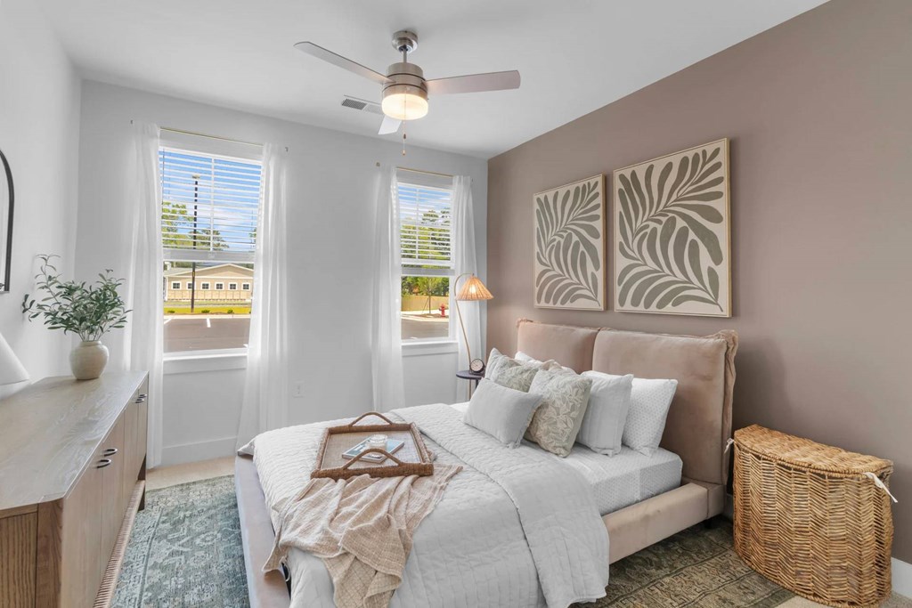 A bedroom with a ceiling fan.