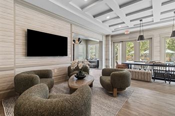 A living room with a flat screen TV mounted on the wall.