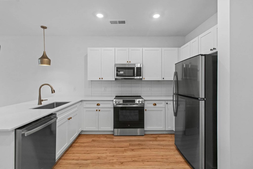 A modern kitchen with white cabinets and stainless steel appliances.