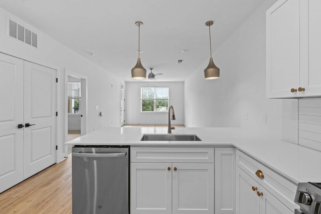 A kitchen with white cabinets and a black countertop.