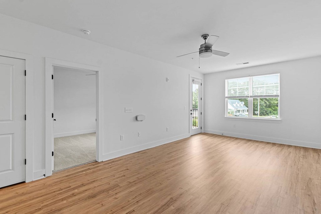 A room with a ceiling fan and a window.