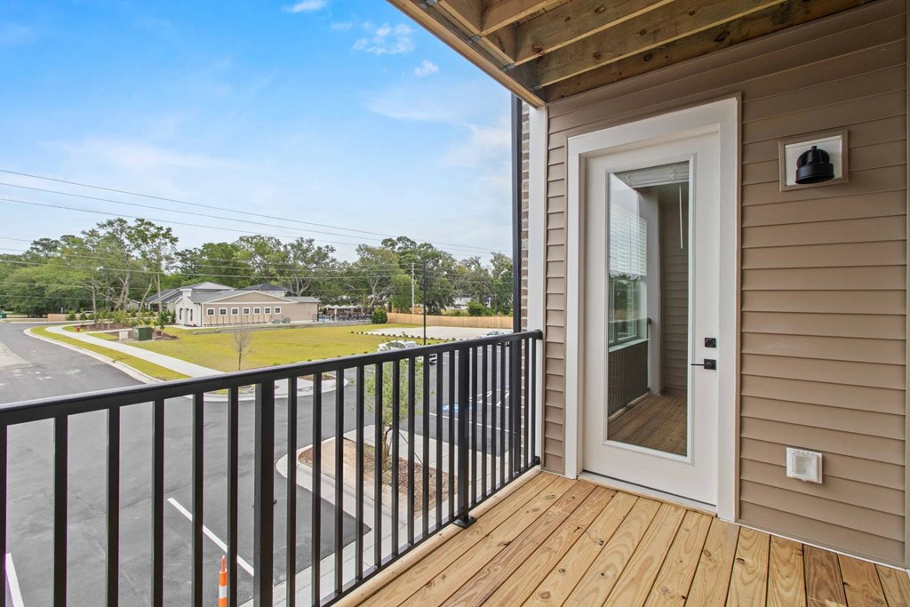A balcony with a black railing and a white door.