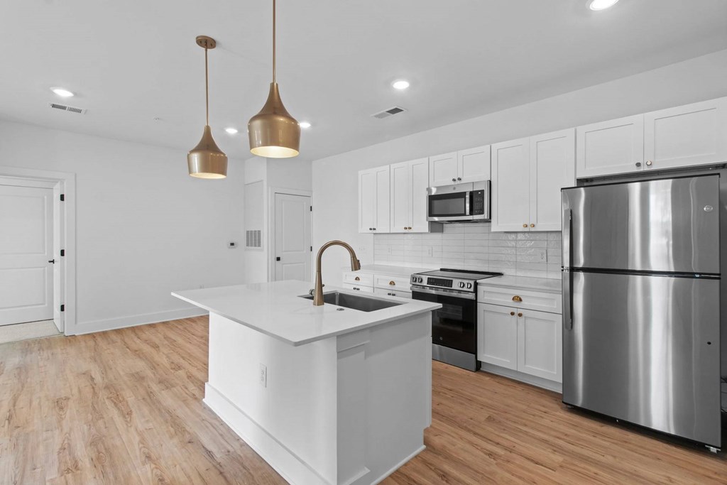 A modern kitchen with a white island and stainless steel appliances.