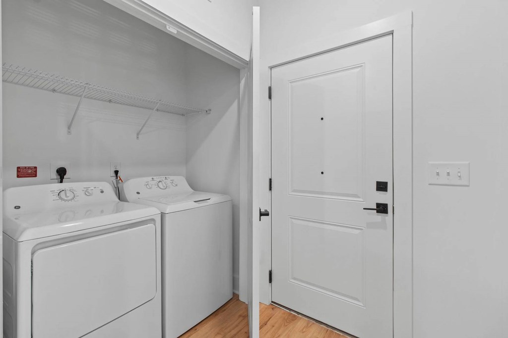 A white laundry room with a washer and dryer.