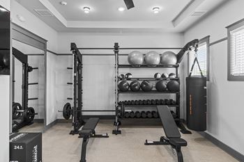 A gym with a variety of equipment including weights and a bench.