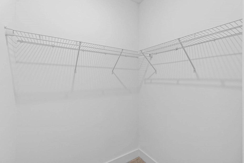 A white wire shelf in a white room.