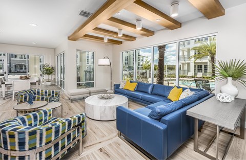 A modern living room with a blue sofa and a wooden ceiling.