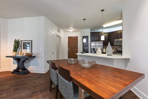 A dining room with a wooden table and chairs.