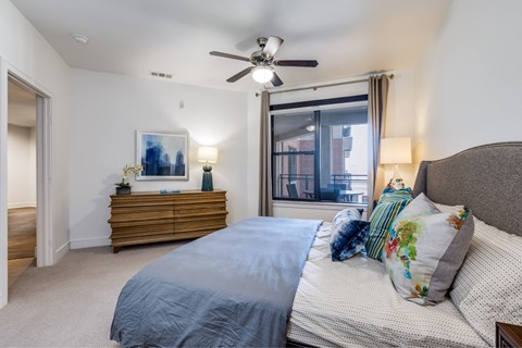 A bedroom with a large bed and a ceiling fan.
