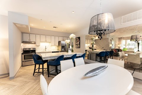 A modern kitchen with a dining table and chairs.