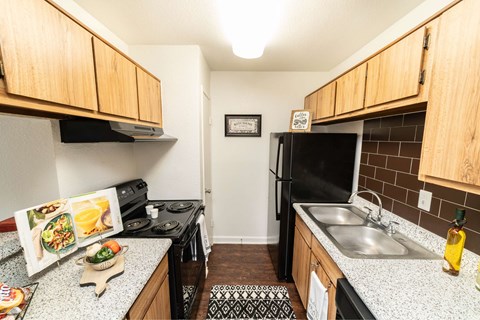 A kitchen with a refrigerator, stove, and sink.