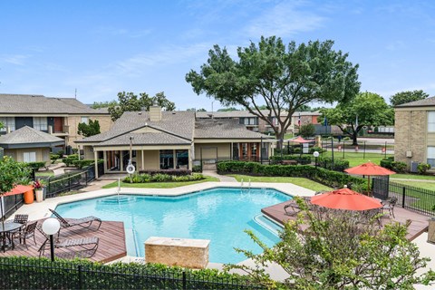 A pool surrounded by a fence and a tree.