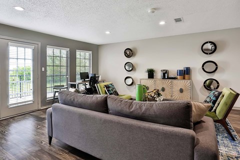 A living room with a grey couch and a green chair.