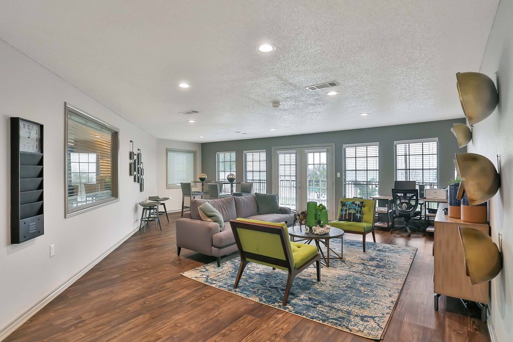 A living room with a green chair and a couch.