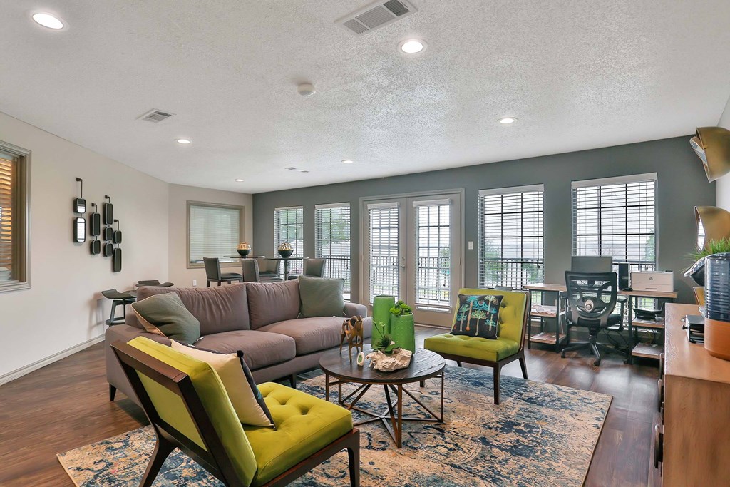 A living room with a grey couch and a green chair.