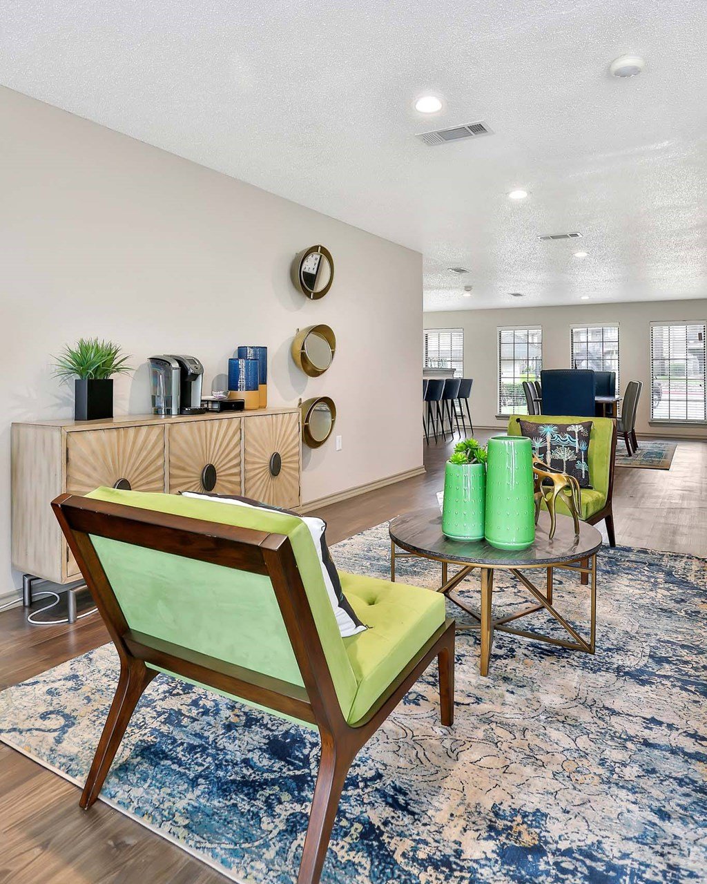 A living room with a green chair and a blue rug.