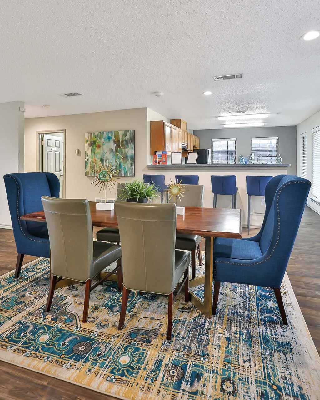 A dining room with a table surrounded by chairs.