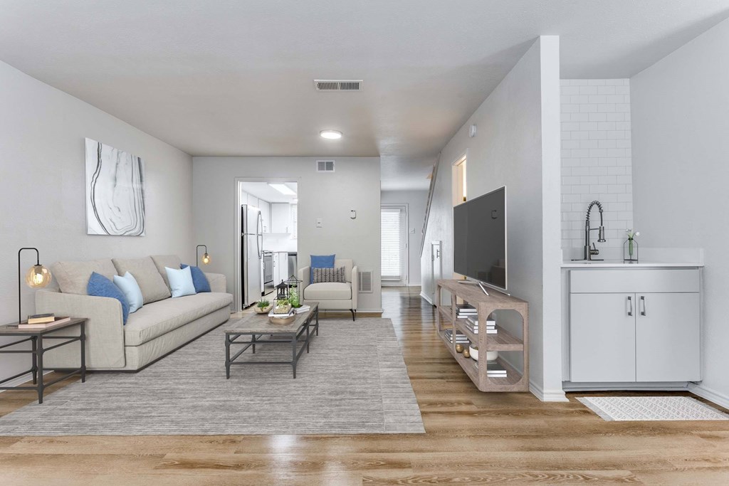 A modern living room with a beige sofa, a grey coffee table, and a white cabinet.