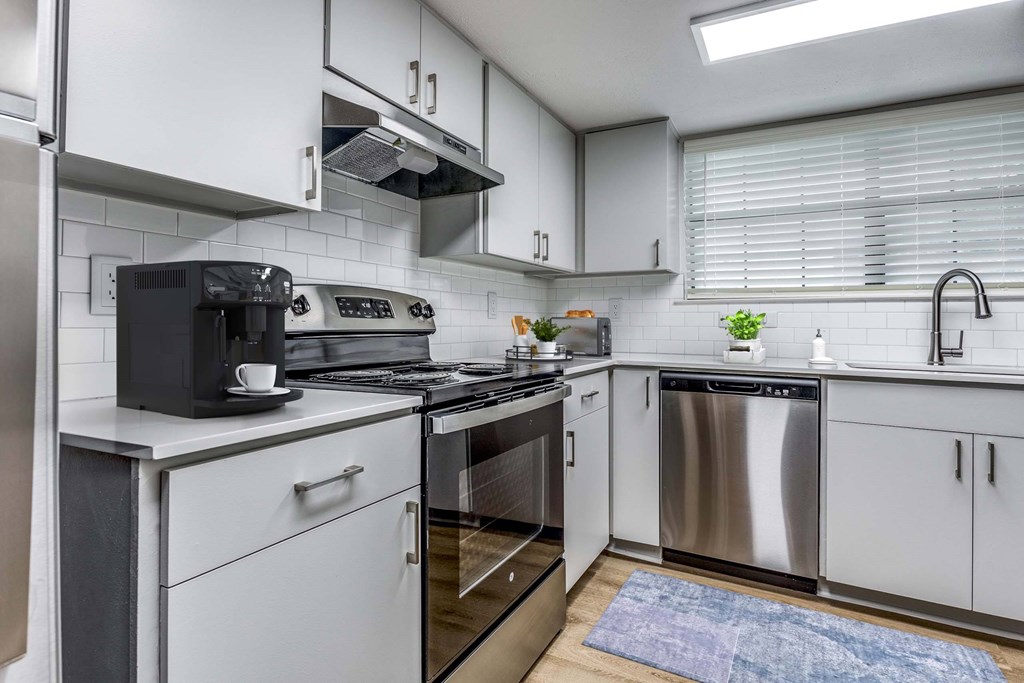 A modern kitchen with stainless steel appliances and white cabinets.