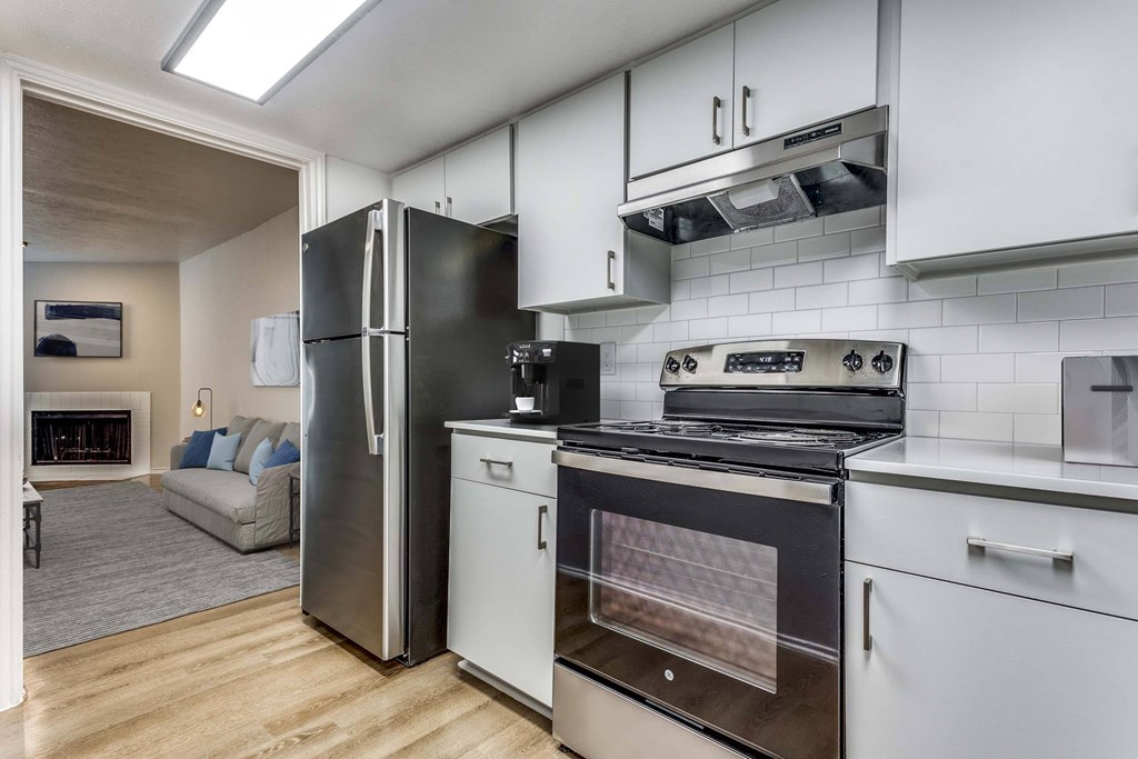 A modern kitchen with a black refrigerator, stove, and oven.