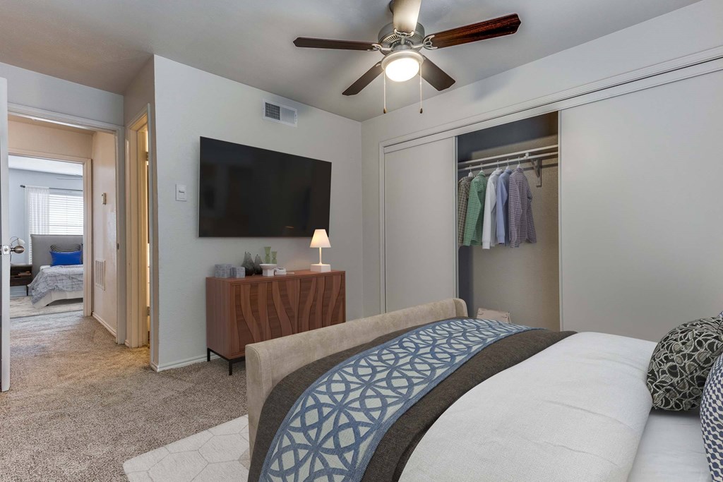 A bedroom with a large bed and a flat screen TV mounted on the wall.