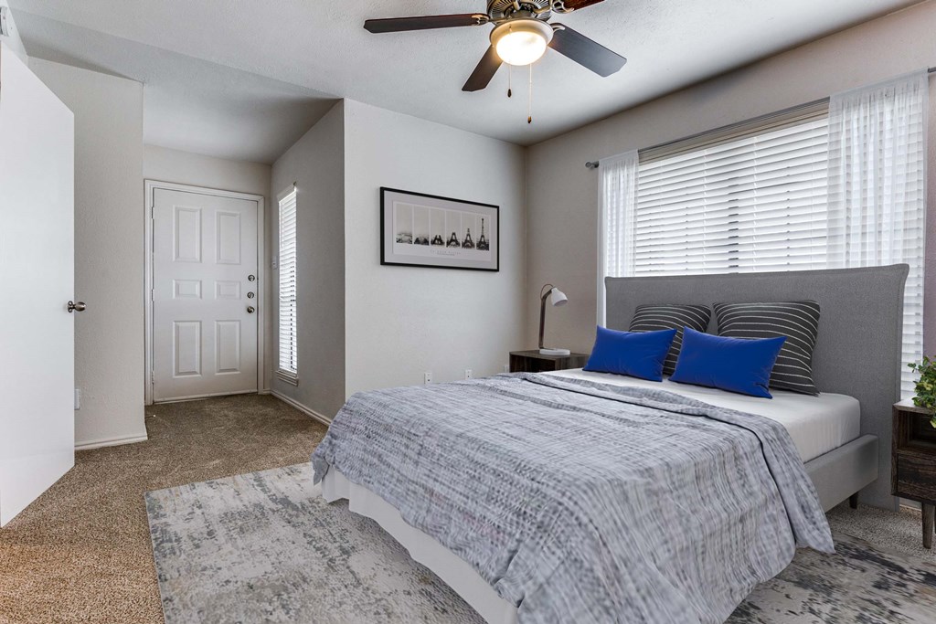 A bedroom with a bed, a ceiling fan, and a rug.