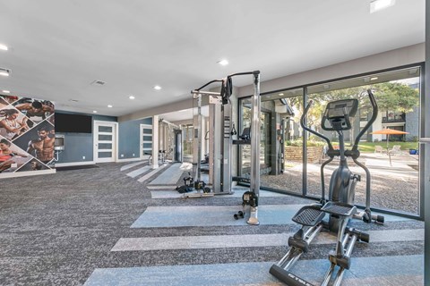 A gym with treadmills, elliptical machines, and other exercise equipment.