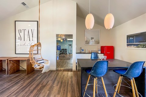 A modern dining room with a black table and blue chairs.