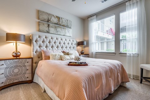 A bedroom with a large bed and a white headboard.