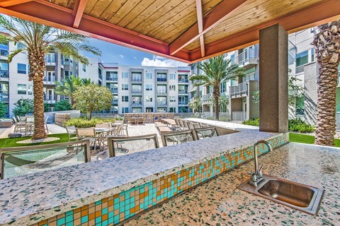 A pool area with a tiled edge and a fountain.