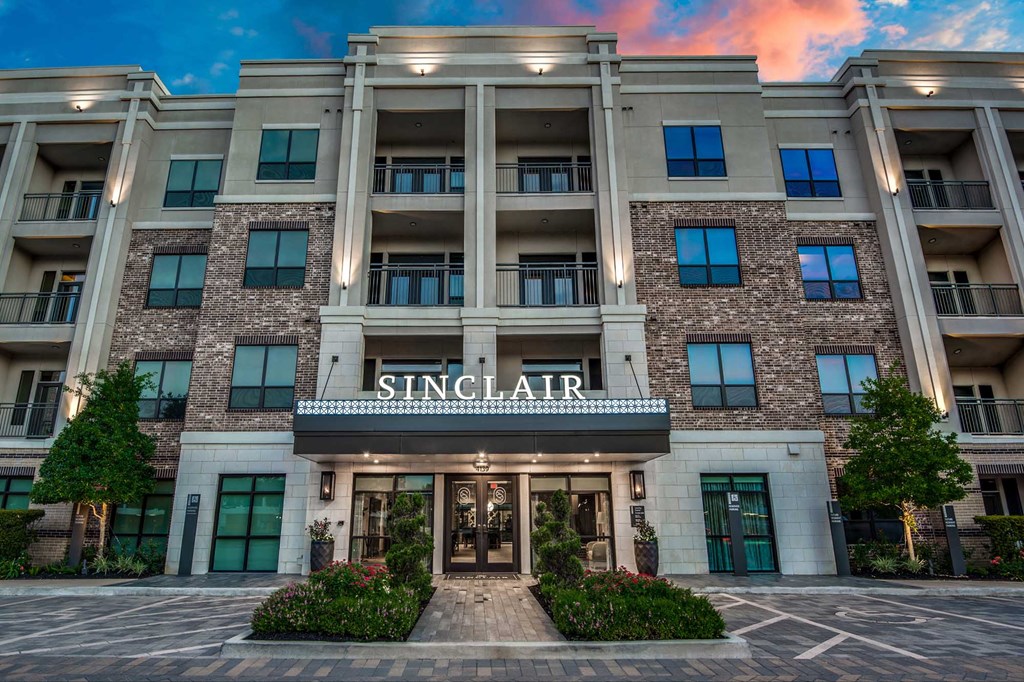 The Sinclair building has a stone facade and is surrounded by greenery.