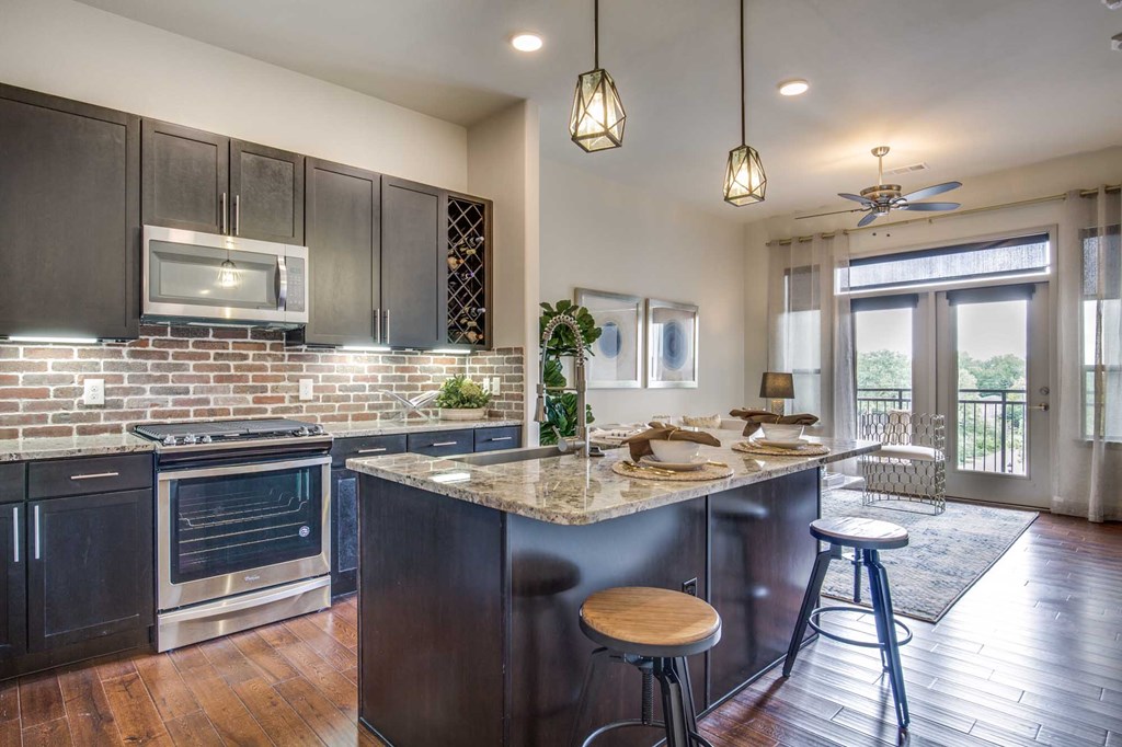 A kitchen with a large island and a dining table set for two.