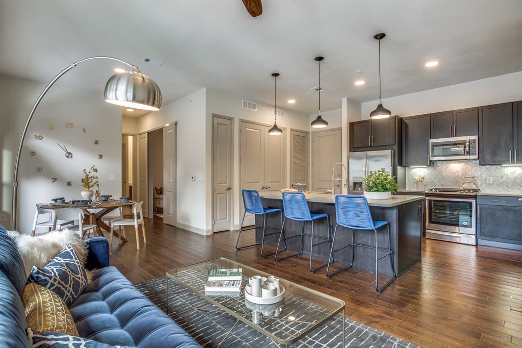 A modern kitchen with dark wood cabinets and a blue sofa.